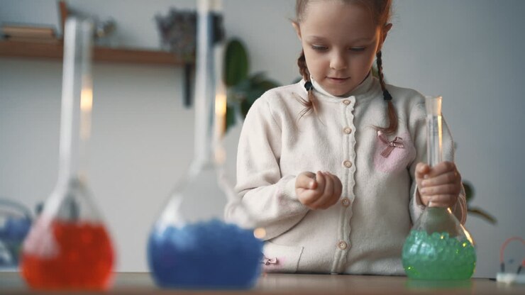 Little girl interested in science plays with laboratory glassware