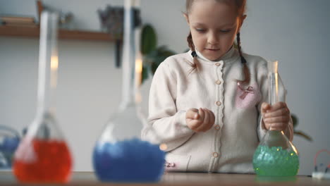 una niña interesada en la ciencia juega con cristalería de laboratorio