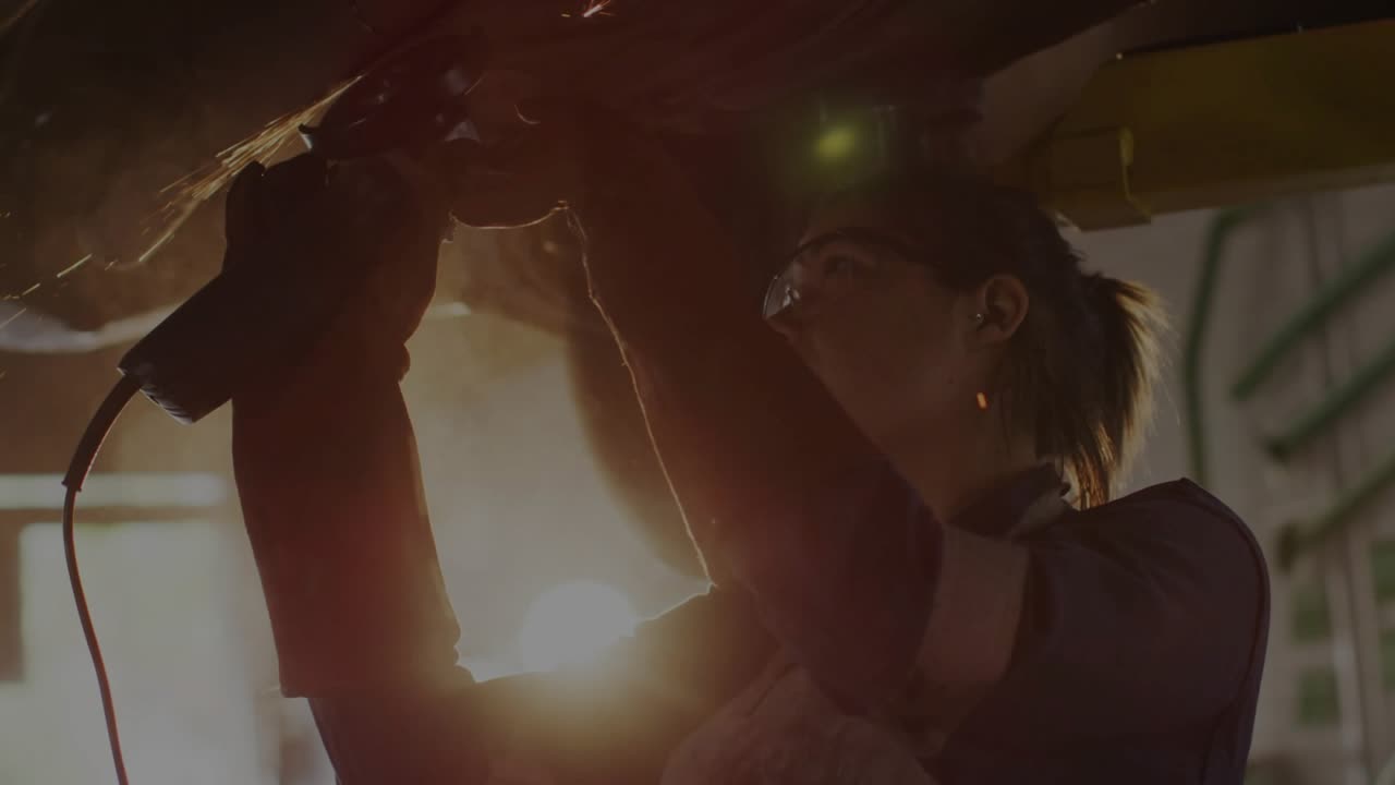 woman technician pressing grinder switch, grinding workpiece under encryption overlay, showing flow