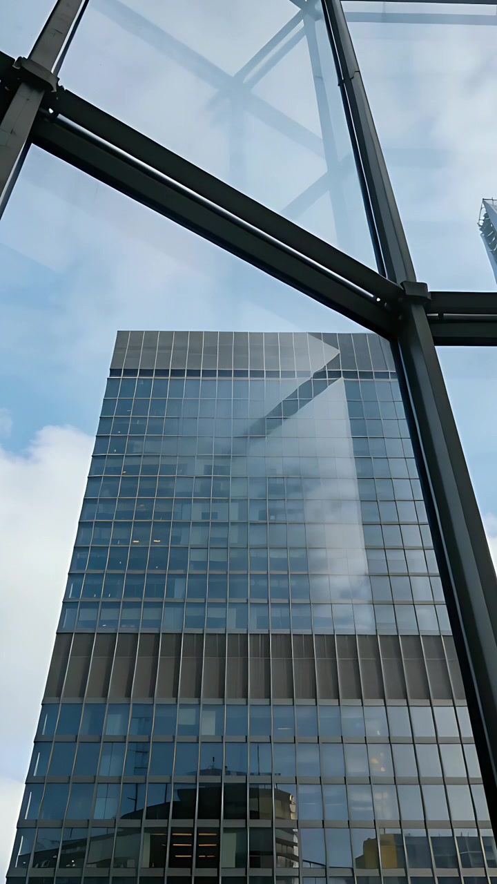 Vídeo vertical: Câmera inclinando para cima do átrio, mostrando a grade da torre de vidro e o montante para contraste.