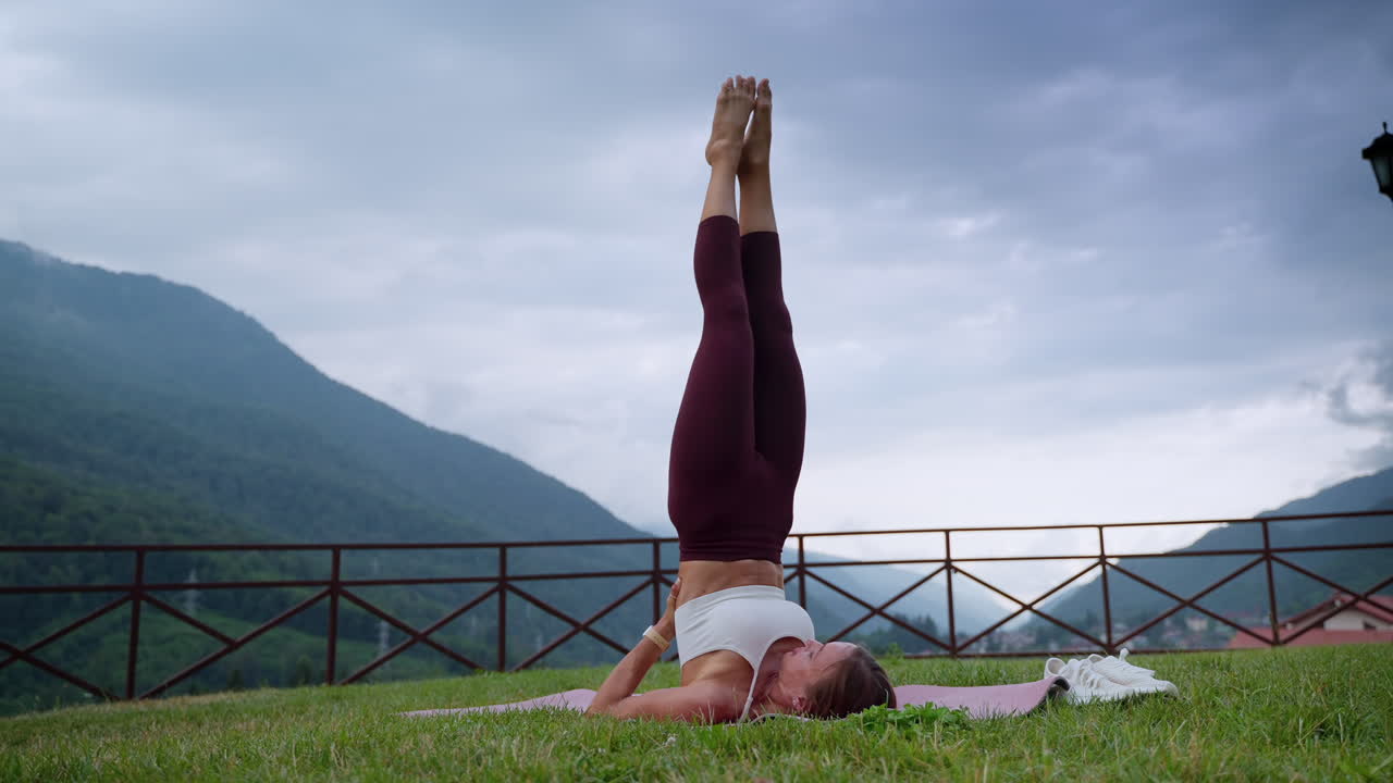 mujer practicando la postura de inversión de yoga en la naturaleza