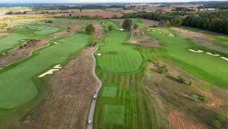 drone flying over golf carts driving between fairways on an oakville golf course