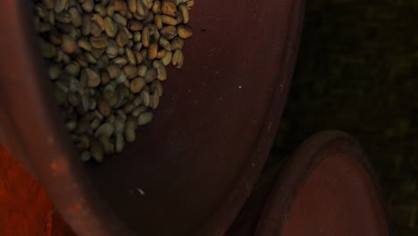 disparo vertical en cámara lenta que revela los caros granos de café kopi luwak en un cuenco rojo para un delicioso café en bali en indonesia
