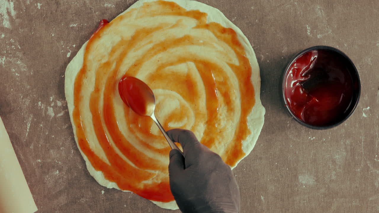 preparando una pizza con salsa