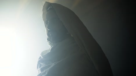 the resurrected jesus christ standing inside the tomb in bright, dramatic, glowing, holy light as representation of the easter sunday resurrection in cinematic slow motion.