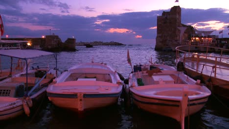 fishing boats bob in the waves at the beautiful and historic fishing village of byblos on the coast of lebanon