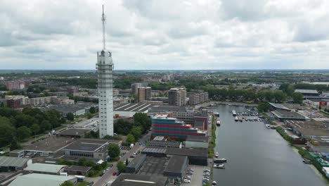 detailed drone view circling a modern telecom tower in alphen aan den rijn with surrounding buildings and marina