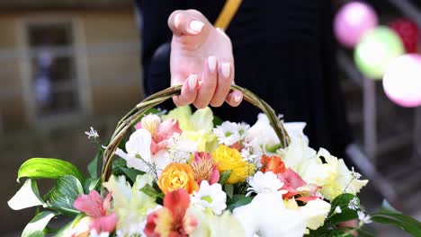 hand holding a basket of colorful flowers