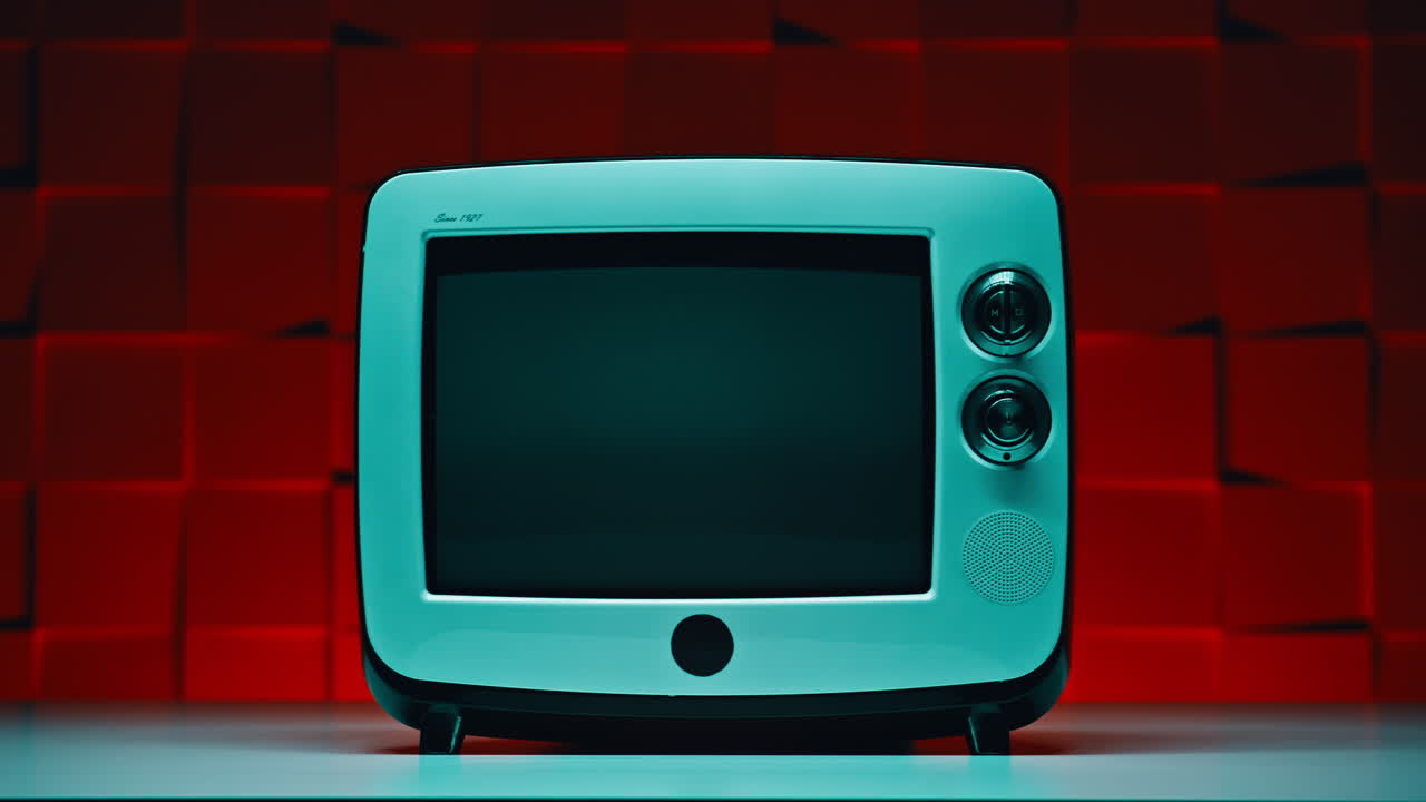 Närbild av liten retro-TV som står på ett bord mot en röd bakgrund. Gammal television