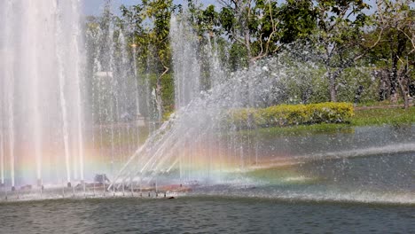 colorful rainbow forms in fountain spray at park