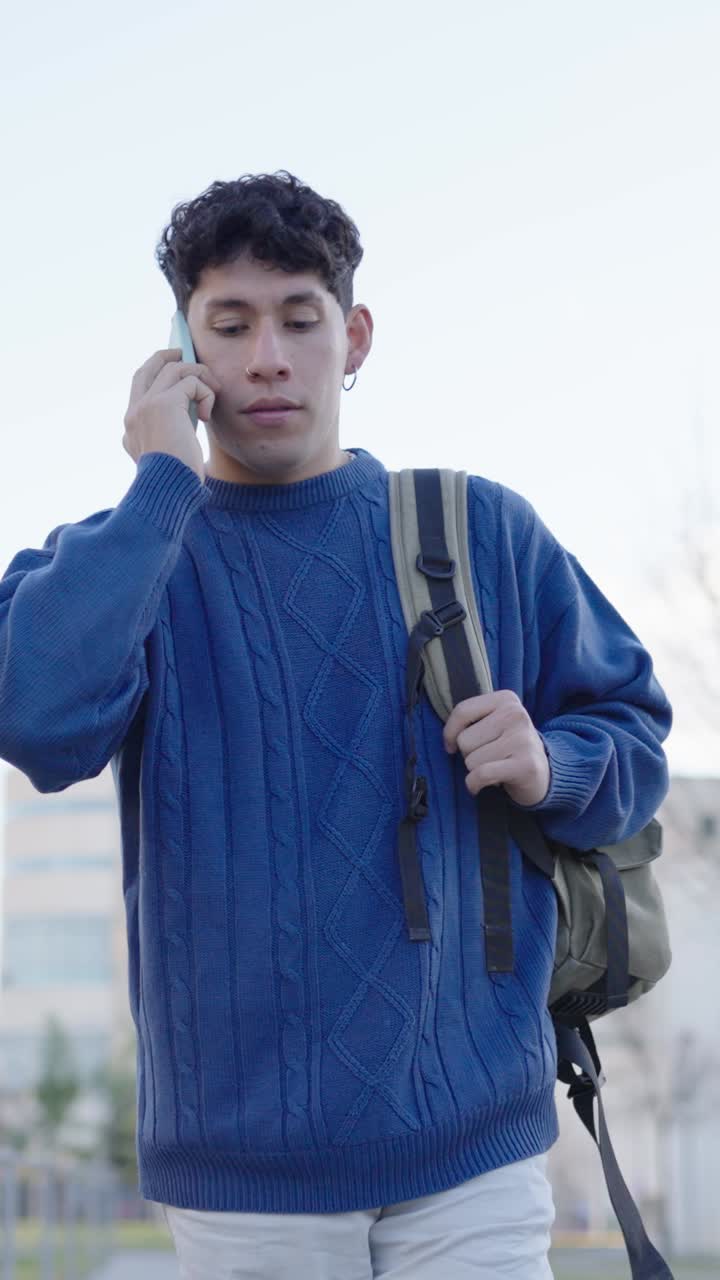 Young student talking on phone while walking. Vertical