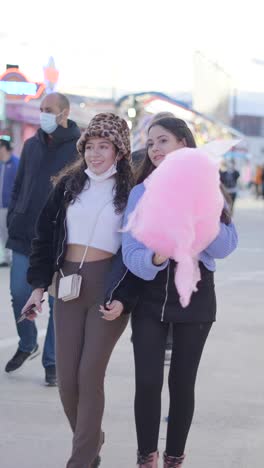 friends enjoying cotton candy at a fair