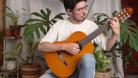 músico tocando una guitarra clásica en casa