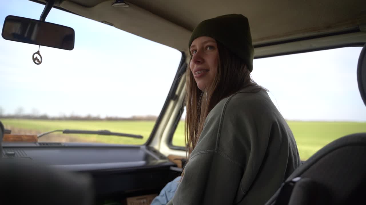 Young red-haired girl with old braces as co-pilot in a caravan.