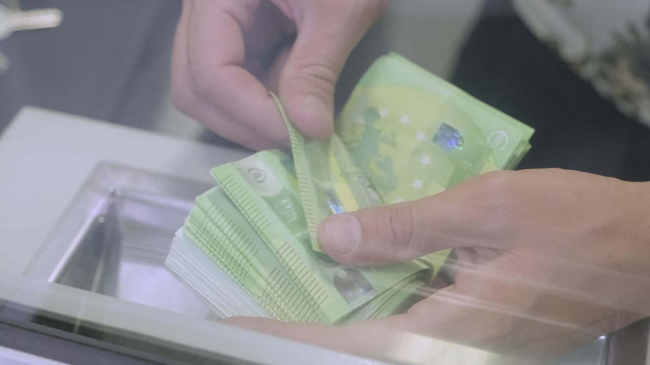 색 배경으로 돈을 세는 손.