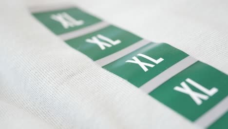 close-up of xl size tags on light gray fabric