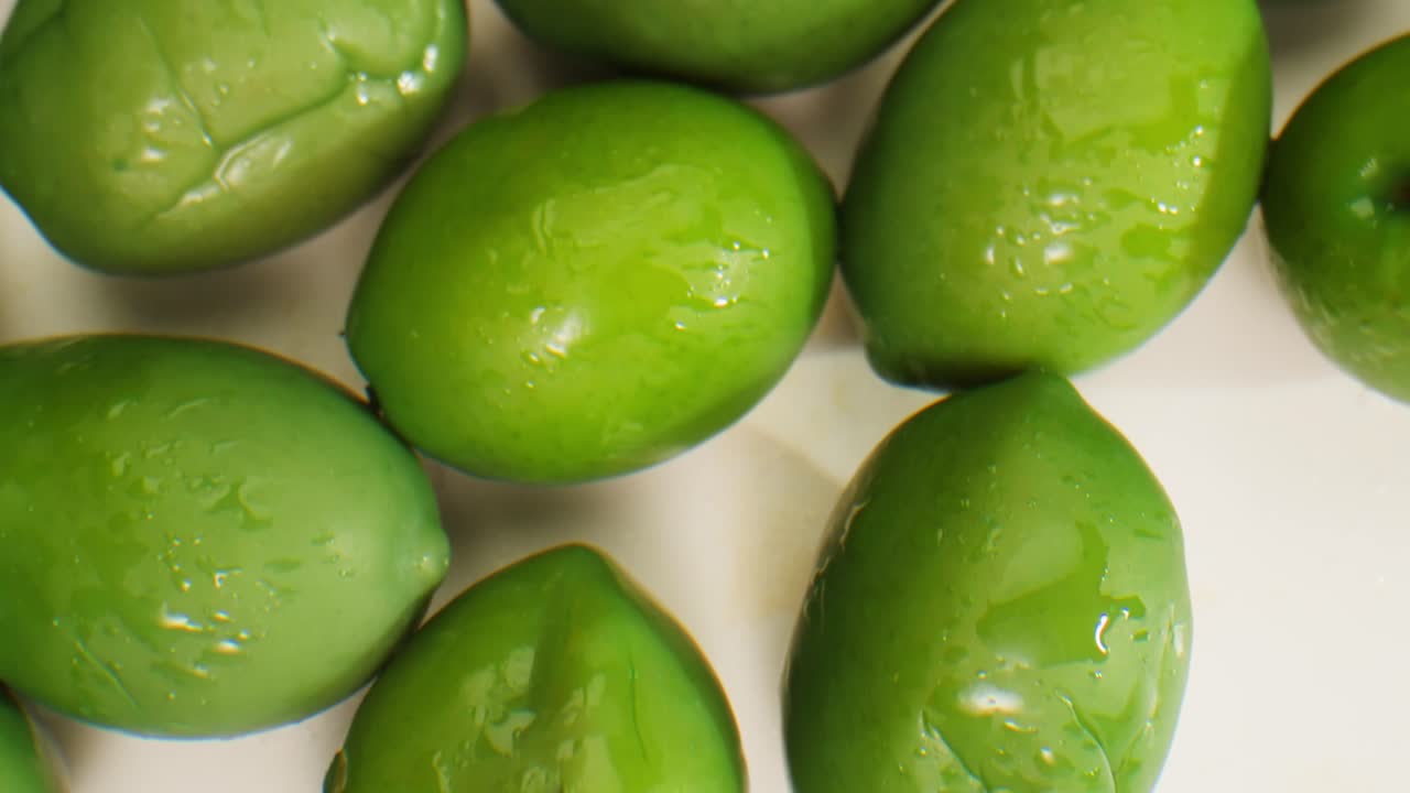 aceitunas verdes redondas en vinagre de grecia como fondo, vista de arriba. imágenes de alta calidad en 4k