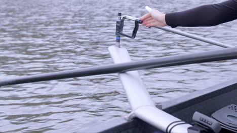 close up clip of a rower unscrewing and attaching their oar to a rigger, outfoors while floating on the utrecht canal in the netherlands