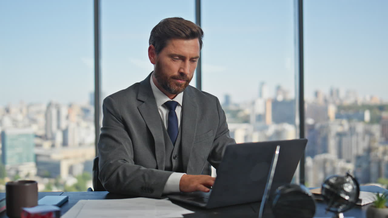 hombre de oficina comenzando el día abriendo la tapa de la computadora portátil. empresario exitoso escritorio de trabajo