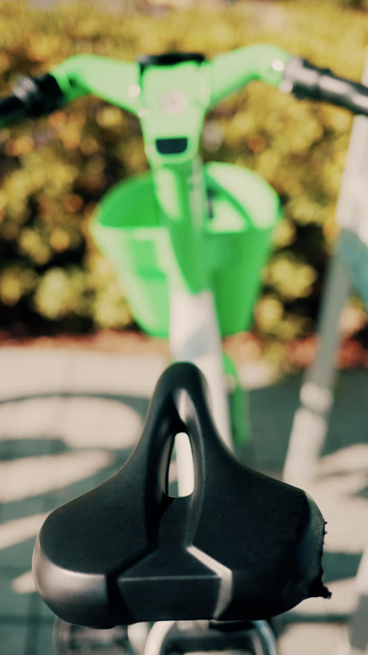 Close up of a green electric bicycle with modern design, parked outdoors under natural light. Vertical