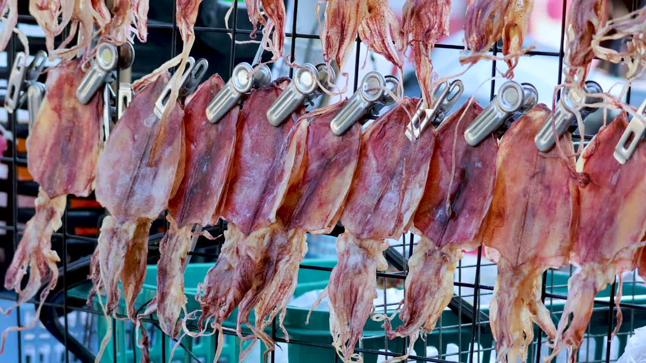 File di calamari essiccati appesi nel mercato di Pattaya