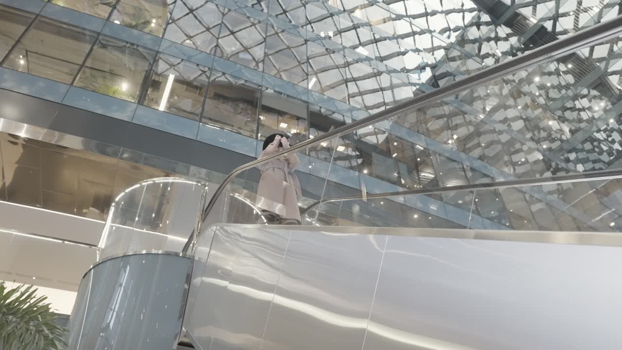 женщина на эскалаторе в современном торговом центре