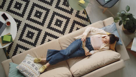 Woman-Reading-Book-on-Sofa