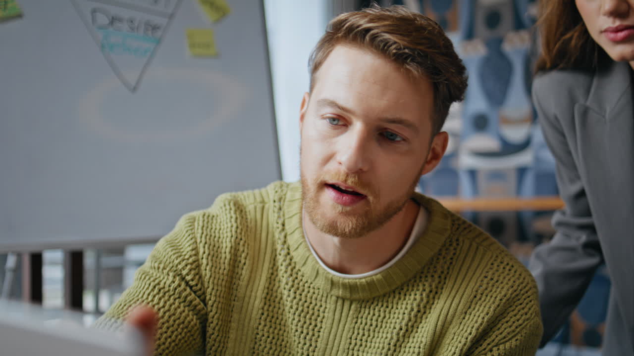 Creative designer explaining project to team at cabinet closeup. Woman assisting