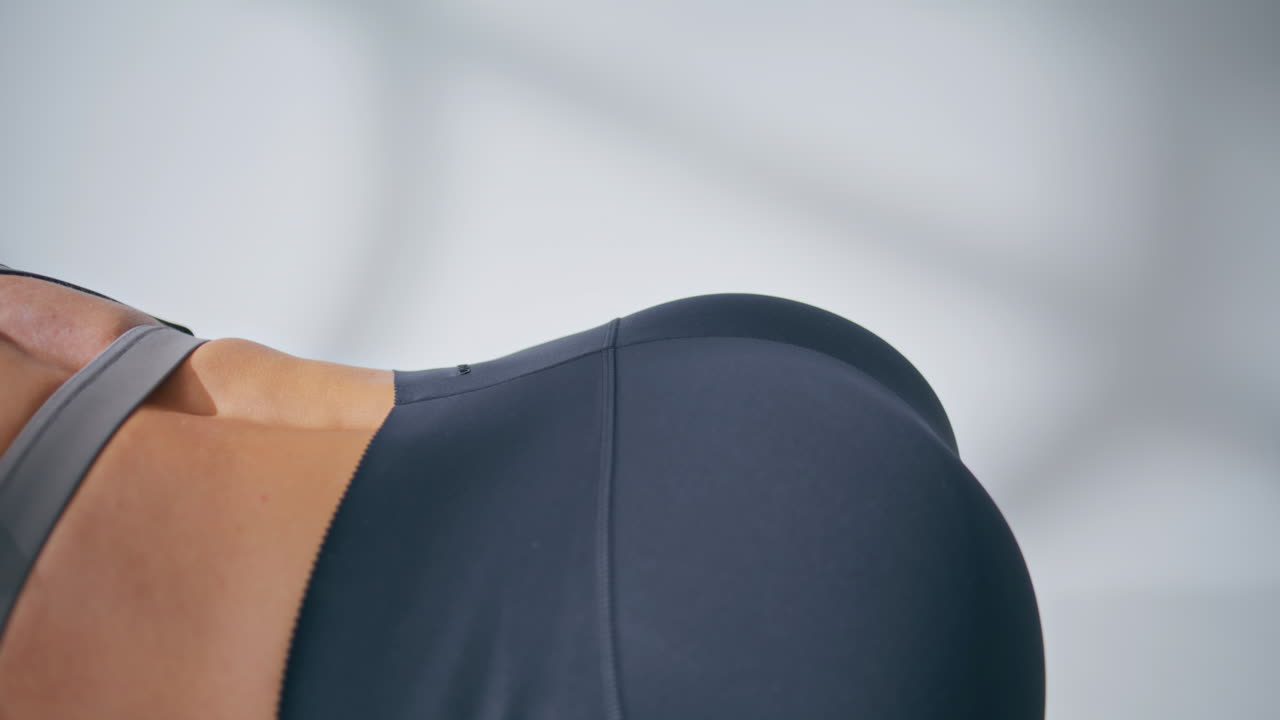 Closeup sportswoman butt raising leg training. Unknown woman burning calories