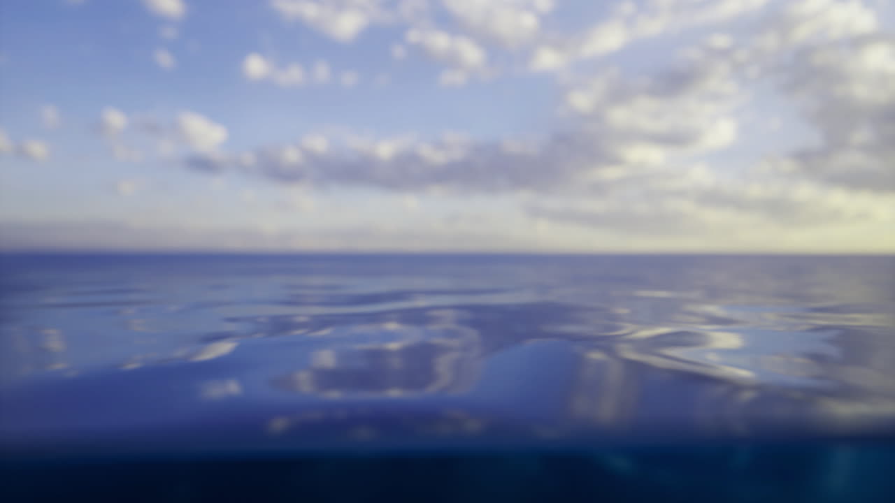 Calm ocean view under clear blue sky with gentle waves at sunset