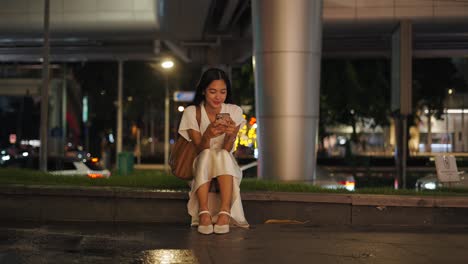 woman using smartphone at night in city