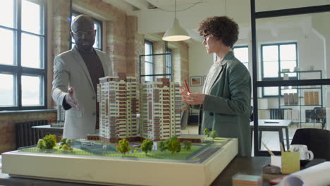 architects or developers discussing a large-scale architectural model in an office