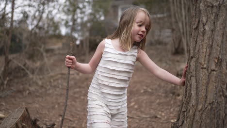 linda niña jugando y explorando en un entorno forestal en cámara lenta