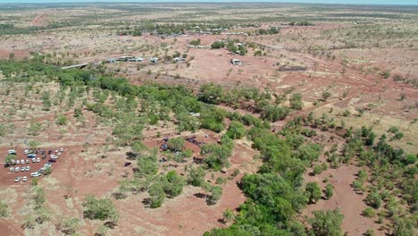 Vista-Aérea-En-Movimiento-Hacia-Adelante-De-La-Ceremonia-Al-Comienzo-Del-Festival-Del-Día-De-La-Libertad-Y-La-Comunidad-De-Kalkaringi-En-El-Fondo,-Territorio-Del-Norte,-Australia