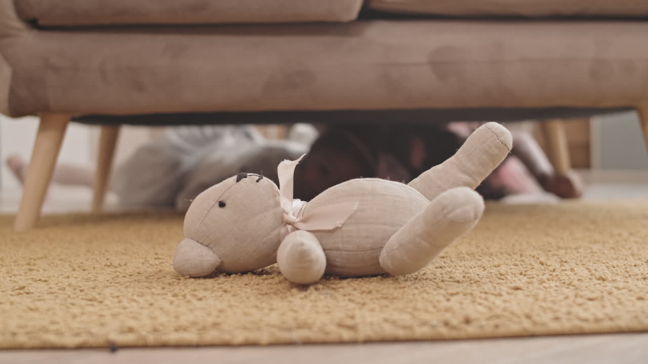Kids Crawling Under Couch for Toy-Bear