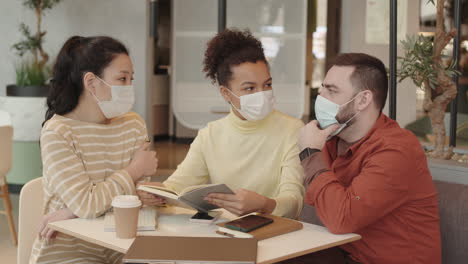 friends in medical masks in cafe