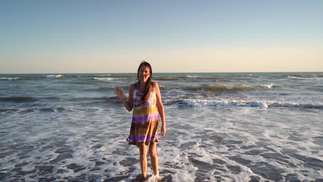 lonely woman at the beach bidding goodbye while walking backward to the sea. suicidal concept. dolly-out