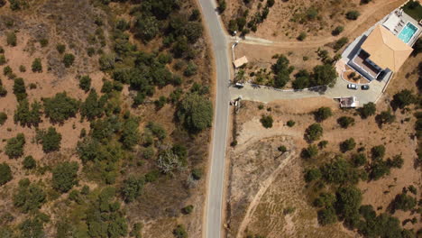 vista superior de la carretera de montaña con villa cercana en un día soleado en algarve, portugal