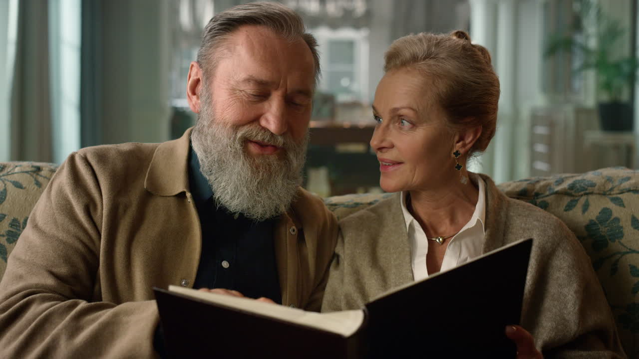 vecchia coppia che ricorda momenti felici con un album fotografico. persone anziane