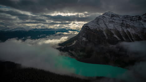 time lapse of magnificent atmosphere scenery above glacial lake and snow capped mountain, clouds and fog inversions, lake louise, banff national park alberta, canada