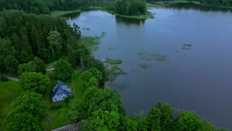 aerial view overlooking a house at a lake, on a gloomy summer evening