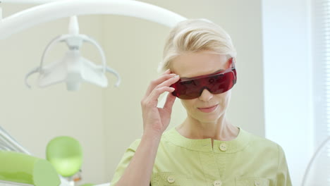 hermosa dentista vestida con gafas de seguridad naranja ultravioleta
