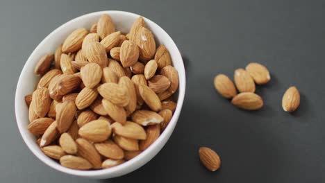 Video-of-fresh-fruit-almonds-in-a-bowl-on-grey-background