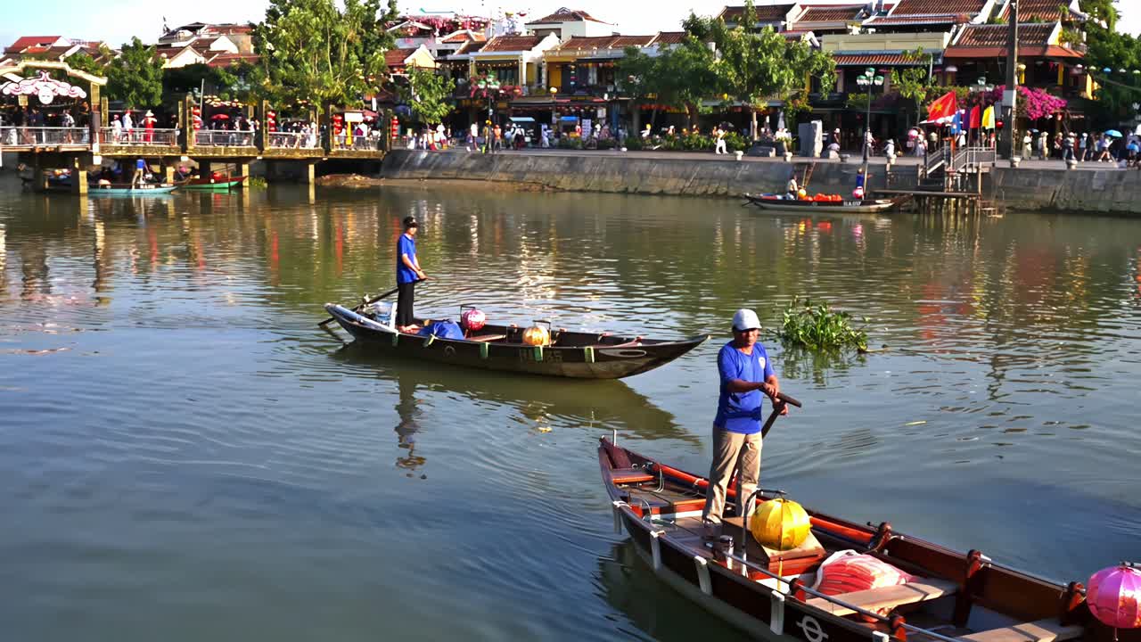 Rowboats serenely travel down Thu Bon River at a section of the Old Quarter in the city of Hoi An, Vietnam.