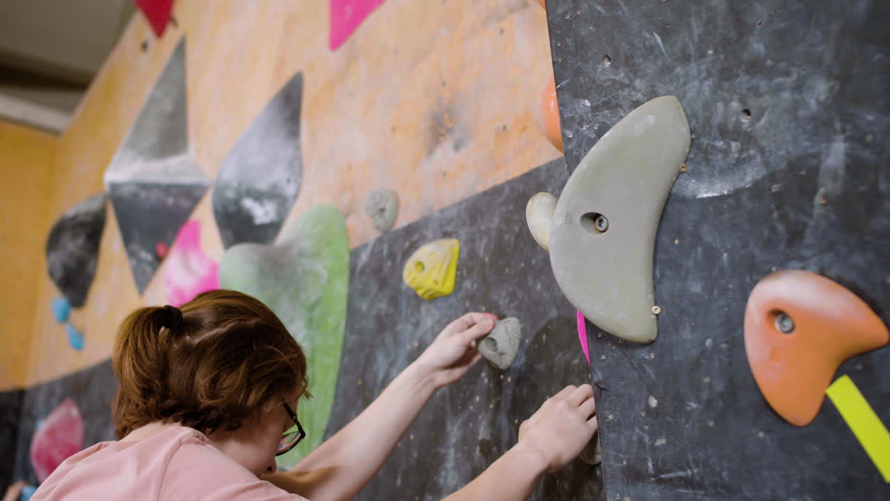 Boy bouldering in a gym