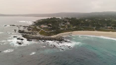 carmel-by-the-sea beach drone video foggy morning surfers on waves - circling land