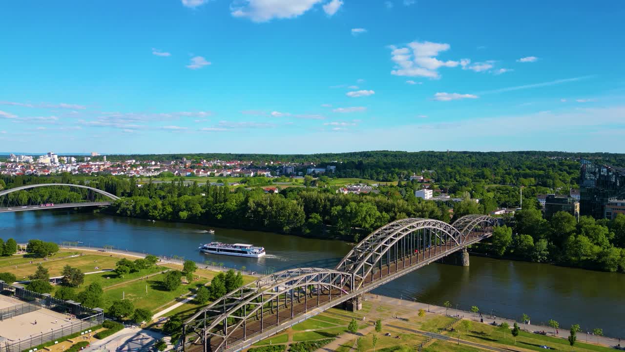 4K Aerial Drone Video of Tour Boat Sailing on the Main River Under Tressel Train Bridge and Past Skate Park in Downtown Frankfurt, Germany