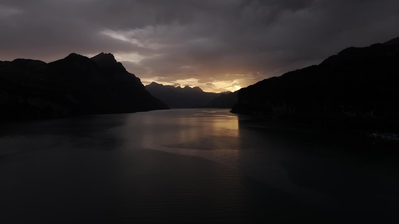 Sun rays beginning to rise over the beautiful Lake Walensee.