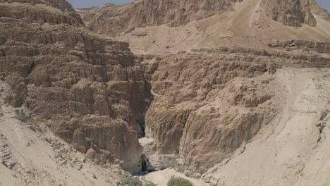 Toma-Aérea-De-Una-Gran-Grieta-En-Un-Acantilado-En-El-Desierto-De-La-Zona-Del-Mar-Muerto-De-Israel,-Toma-De-Un-Dron