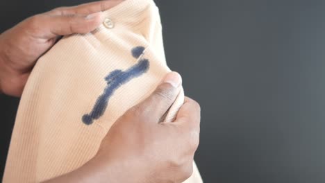 person holding cloth with ink stain